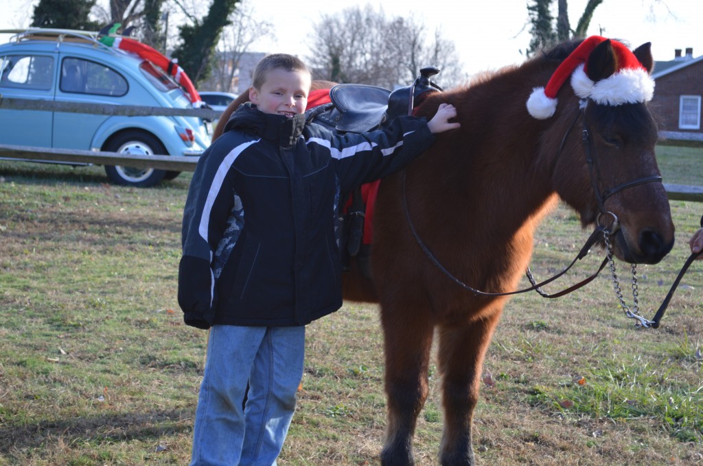 Boy and a beautiful pony in a santa hat